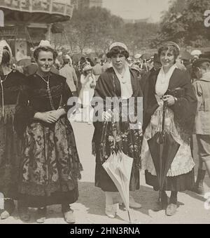 Photo vintage des filles françaises en robe traditionnelle avec des casquettes en dentelle et des tabliers en soie à la foire. 1900s Banque D'Images