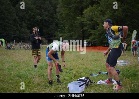 AICKENS (NOUVELLE-ZÉLANDE), le 12 FÉVRIER 2022; Un employé des médias s'enregistre auprès de concurrents alors qu'il prépare son équipement au point de passage pour la section de la course de montagne 33km du triathlon Côte à Côte Banque D'Images