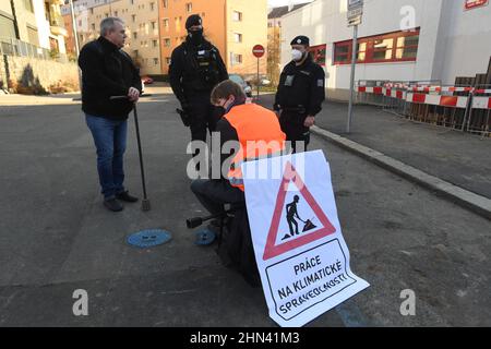 Prague, République tchèque. 14th févr. 2022. Un groupe de militants écologistes a arrêté le flux d'eau vers le bâtiment du ministère de l'Environnement pour protester contre l'accord entre la République tchèque et la Pologne sur l'exploitation minière dans la mine de charbon brun de Turow, le 14 février 2022, à Prague (République tchèque). Il y a un activiste avec la bannière "Work in Climate Justice", qui s'assoit sur une chaise au-dessus de la vanne de la pipe à eau, qu'il avait manipulée auparavant. Crédit : Katerina Sulova/CTK photo/Alamy Live News Banque D'Images