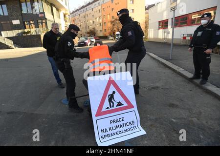 Prague, République tchèque. 14th févr. 2022. Un groupe de militants écologistes a arrêté le flux d'eau vers le bâtiment du ministère de l'Environnement pour protester contre l'accord entre la République tchèque et la Pologne sur l'exploitation minière dans la mine de charbon brun de Turow, le 14 février 2022, à Prague (République tchèque). Il y a un activiste avec la bannière "Work in Climate Justice", qui s'assoit sur une chaise au-dessus de la vanne de la pipe à eau, qu'il avait manipulée auparavant. Les policiers retirent un activiste d'une chaise. Crédit : Katerina Sulova/CTK photo/Alamy Live News Banque D'Images