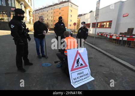 Prague, République tchèque. 14th févr. 2022. Un groupe de militants écologistes a arrêté le flux d'eau vers le bâtiment du ministère de l'Environnement pour protester contre l'accord entre la République tchèque et la Pologne sur l'exploitation minière dans la mine de charbon brun de Turow, le 14 février 2022, à Prague (République tchèque). Il y a un activiste avec la bannière "Work in Climate Justice", qui s'assoit sur une chaise au-dessus de la vanne de la pipe à eau, qu'il avait manipulée auparavant. Crédit : Katerina Sulova/CTK photo/Alamy Live News Banque D'Images