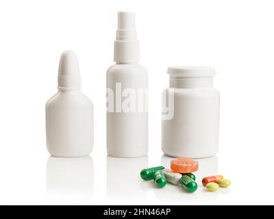 Flacons de médicaments blancs et tas de pilules colorées isolés sur fond blanc avec réflexions Banque D'Images