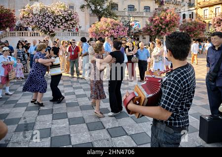 Les gens dansent et s'amusent sur la place principale de Taormina Banque D'Images