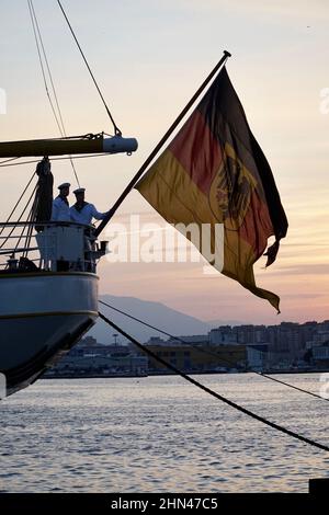 13 février 2022, Espagne, Málaga: Le navire d'entraînement à voile de la Marine allemande Gorch Fock se trouve dans le port tandis que deux marins rabougent le drapeau à la poupe. Le Gorch Fock doit mettre la voile à la mi-février avec 80 à 100 candidats officiers pour le premier voyage d'entraînement après la reprise. Les cas Corona à bord avaient retardé le départ. Photo: Alexander Blum/dpa Banque D'Images