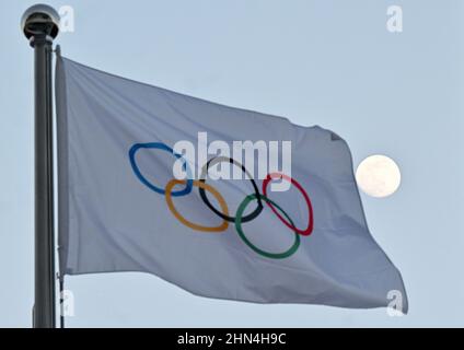 Pékin, Chine. 14th févr. 2022. Olympia, la lune peut être vue derrière le drapeau avec les anneaux olympiques. Credit: Peter Kneffel/dpa/Alay Live News Banque D'Images