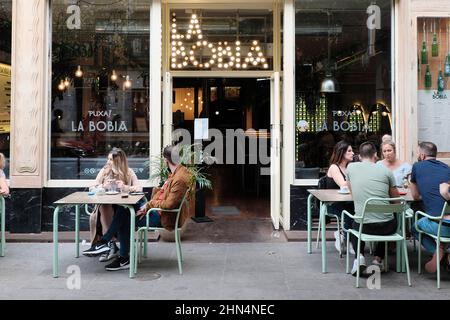 Personnes assises sur la terrasse de la Bobia, un bar bien connu dans le centre-ville de Madrid. Banque D'Images