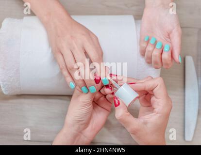 Manucure peignant les ongles du client avec du vernis en salon Banque D'Images