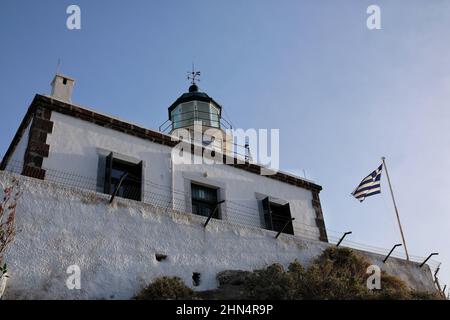 Le beau phare Akrotiri sur l'île de Santorini Grèce et le drapeau grec à côté Banque D'Images