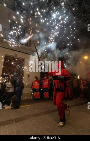 Valence, Espagne - 11 février 2022 : un homme habillé comme un démon avec un sparkler dans sa main qui court dans la rue pendant le festival traditionnel espagnol, c Banque D'Images