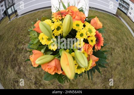 Munich, Allemagne. 14th févr. 2022. Une femme tient un bouquet de fleurs qu'elle a reçu en cadeau le jour de la Saint-Valentin. Credit: Felix Hörhager/dpa/Alay Live News Banque D'Images