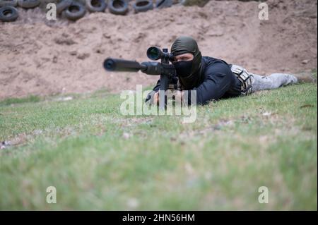 Homme avec le fusil vu posé sur l'herbe Banque D'Images