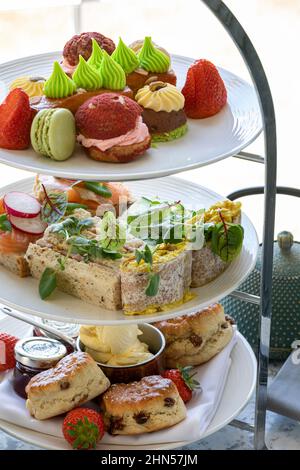 Le thé de l'après-midi, les sandwiches, les gâteaux, les scones et le thé sont servis sur un support à gâteaux Banque D'Images