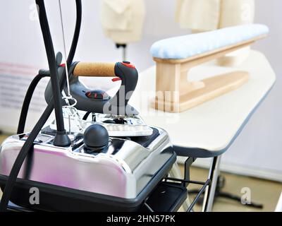 Fer et planche à repasser modernes dans l'atelier de couture Banque D'Images