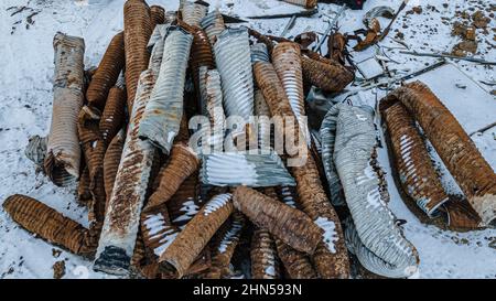 Couvert de neige, perdu et oublié un tuyau de tuyaux en acier ondulé Banque D'Images