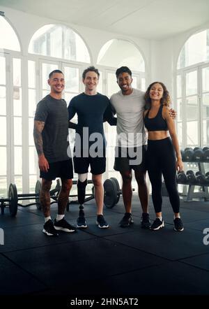 Divers groupes d'amis s'entraîner dans une salle de gym moderne . Portrait d'un groupe d'amis multiraciaux souriant à l'appareil photo Banque D'Images