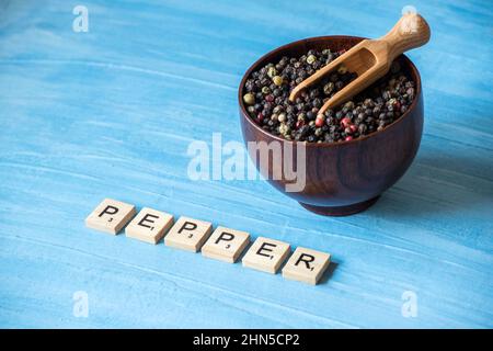 grains de poivre sur bol en bois Banque D'Images