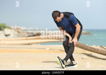 Coureur s'étirant sur la plage Banque D'Images