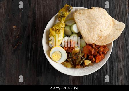 Casquette Lontong Go meh. Plat de gâteau au riz péranakan avec curry de poulet, chayote épicé, œuf dur et craquelins aux crevettes. Vue de dessus Banque D'Images