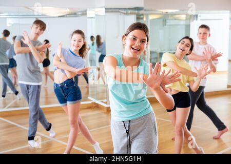 Une adolescente s'exerçant pendant un cours de danse de groupe Banque D'Images