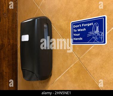 Panneau bleu avec distributeur de savon rappelant aux gens de se laver les mains Banque D'Images