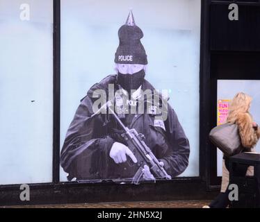 Manchester, Royaume-Uni, 14th février 2022. Une fresque humoristique présentant le Premier ministre britannique Boris Johnson est apparue sur l'ancien magasin Debenhams dans le centre de Manchester, au Royaume-Uni. Réalisée par 'Foka Wolf', une artiste de rue, la fresque a la tête de Boris Johnson, portant un chapeau de fête, sur l'image d'un policier armé. Il y a une enquête de la police métropolitaine en cours sur des rassemblements sociaux ou des parties au 10 Downing Street pendant les écluses de Covid-19, de coronavirus ou de Corona. Un rapport de la fonctionnaire Sue Gray critiquait certains rassemblements dans ce pays. Crédit : Terry Waller/Alay Live News Banque D'Images