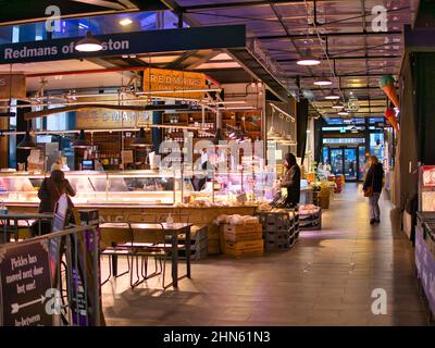 Comptoirs de boucher locaux et leurs clients dans le nouveau Market Hall de Preston, Lancashire, Royaume-Uni. Banque D'Images