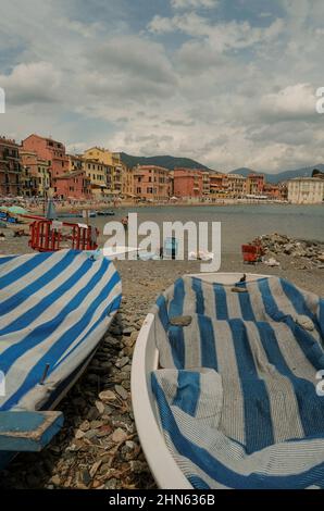 Bateaux sur la plage à rayures bleues sur la baie de Silence, Baia del Silenzio à Sestri Levante, Italie. Destinations de voyage Banque D'Images