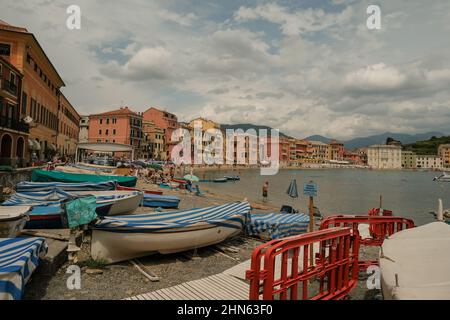 Bateaux garés sur la plage avec une couverture à rayures bleues sur la baie de Silence, Baia del Silenzio à Sestri Levante, Italie. Destinations de voyage Banque D'Images