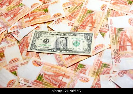 Un billet d'un dollar se trouve parmi un billet de 5000 roubles Banque D'Images