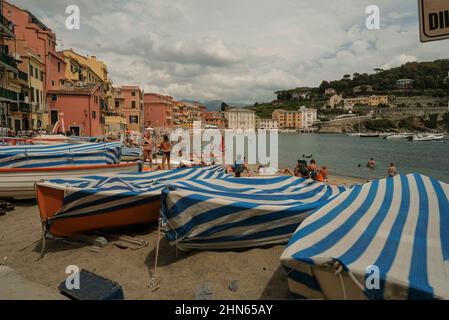 Juillet 2021 Sestri Levante, Italie: Bateaux garés sur la plage avec une couverture rayée bleue sur la baie du Silence, Baia del Silenzio à Sestri Levante, Italie Banque D'Images