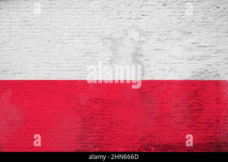 Photo plein cadre d'un drapeau de la Pologne peint sur un mur en brique plâtrée. Banque D'Images