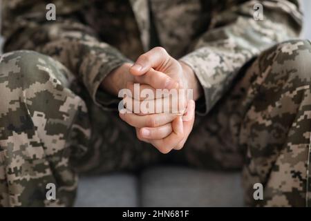 Court de soldat assis sur un canapé seul Banque D'Images