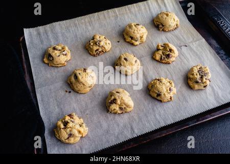 Biscuits aux pépites de chocolat au fromage à la crème en lot : biscuits aux pépites de chocolat sur une feuille de papier sulfurisé Banque D'Images