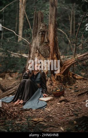 Une mystérieuse sorcière marche dans une forêt sombre Banque D'Images