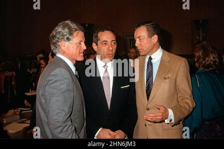 Le gouverneur Mario Cuomo (démocrate de New York), au centre, s’entretient avec le sénateur américain Edward M. « Ted » Kennedy (démocrate du Massachusetts), à gauche et le sénateur américain Orrin Hatch (républicain de l’Utah), à droite, avant de témoigner devant la Commission du travail et des ressources humaines du Sénat américain à Capitol Hill à Washington, DC le 23 février 1988. Crédit: Arnie Sachs/CNP Banque D'Images