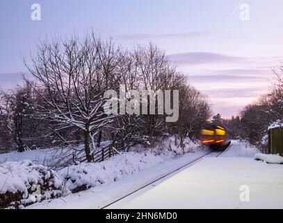 Train passant par la gare de Kildale après une lourde neige. Village de Kildale, North Yorkshire, Angleterre, Royaume-Uni Banque D'Images