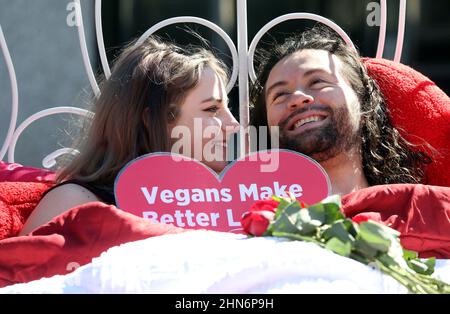 Raleigh, Caroline du Nord, États-Unis. 14th févr. 2022. SKY DAWSON, l, de fort Wayne, IN et LUIS CORREAL d'Atlanta, GA se câlin dans un lit au cœur du centre-ville de Raleigh, NC avec un message disant ''˜vegans font de meilleurs amoureux.' Les gens pour le traitement éthique des animaux ont mis en place l'exposition dans le centre-ville en choisissant la Saint-Valentin pour rappeler à chacun désireux de plaire à leurs partenaires que le cholestérol dans la viande et les produits laitiers peut obstruer les artères à tous vos organes, pas seulement le coeur. (Image de crédit : © Bob Karp/ZUMA Press Wire) Banque D'Images