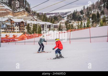Garçon apprenant à skier, à s'entraîner et à écouter son instructeur de ski sur la piste en hiver Banque D'Images