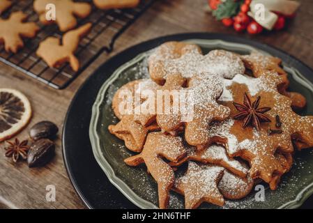 Biscuits traditionnels au gingembre de Noël saupoudrés de sucre en poudre sur la plaque de fermeture Banque D'Images