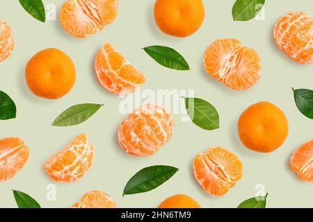 Motif sans couture de mandarines entières ou de fruits orange mandarin, de segments pelés et de feuilles sur fond vert Banque D'Images