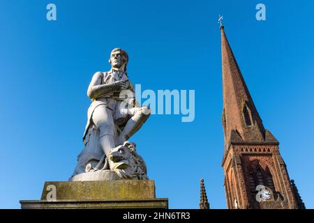 Statue en marbre de Carrare du poète Robert Burns, Church place, centre-ville de Dumfries, Écosse, avec une partie de l'église Greyfriars en arrière-plan. Banque D'Images