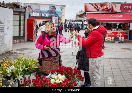 14 février 2022 : sur la côte de Kadikoy, un couple achète des roses rouges au fleuriste. Les difficultés économiques de la Turquie ont eu un impact sur les ventes de fleurs et de cadeaux avant la Saint-Valentin, car les consommateurs ont été contraints d'accorder la priorité aux besoins de base tels que les produits alimentaires. Au cours de cette période, lorsque le taux d'inflation annuel a augmenté pour le huitième mois consécutif et a atteint 48,69% en janvier 2022, il a été difficile de trouver un acheteur lorsqu'une seule augmentation a été vendue pour 50 à 60 liras à Istanbul le 14 février 2022. (Image de crédit : © Tolga Ildun/ZUMA Press Wire) Banque D'Images