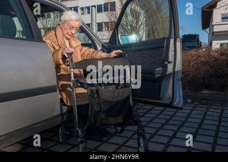 Femme âgée avec aider le roller à sortir de la voiture Banque D'Images