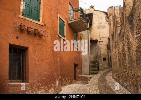 Quartier historique des châteaux, via Posterna, dans la petite ville de Malcesine sur les rives du lac de Garde, province de Vérone, Vénétie, Italie. Les murs du château sont à droite Banque D'Images