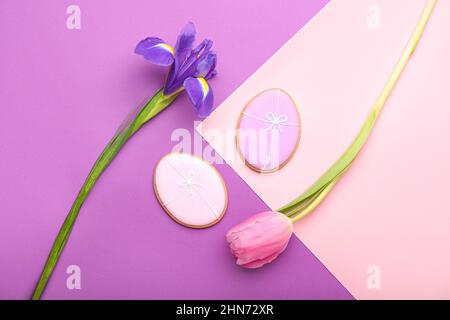 Délicieux biscuits de Pâques et fleurs sur fond de couleur Banque D'Images