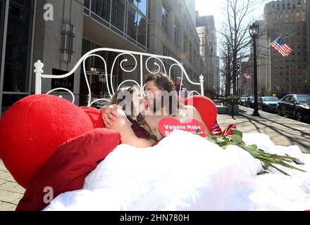 Raleigh, Caroline du Nord, États-Unis. 14th févr. 2022. SKY DAWSON de l'Indiana et LUIS CORREAL de Géorgie se blottent dans un lit au cœur du centre-ville avec un message disant « les végétaliens font de meilleurs amoureux » les gens pour le traitement éthique des animaux ont mis en place l'exposition dans le centre-ville en choisissant la Saint-Valentin pour rappeler à chacun désireux de plaire à leurs partenaires que le cholestérol dans la viande et les produits laitiers peut obstruer les artères à tous vos organes, pas seulement le coeur. (Image de crédit : © Bob Karp/ZUMA Press Wire) Banque D'Images