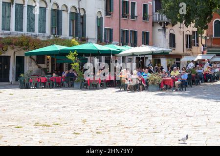 touristes dans l'un des nombreux cafés et restaurants situés dans les rues vénitiennes Banque D'Images