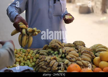 Un homme asiatique achat ou achat de fruits frais du chariot bananes Banque D'Images