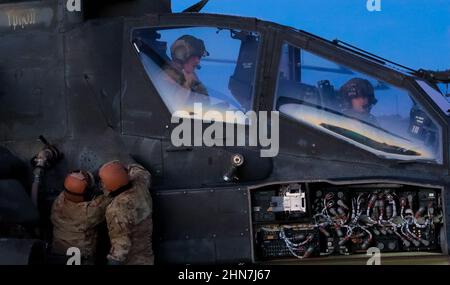 Les réparateurs de systèmes d'armement, affectés au 1-501st Bataillon, Brigade de l'aviation de combat, 1st Armored Division, effectuent des vérifications mécaniques et électriques après le vol d'un hélicoptère Apache AH-64 qui retourne au camp après avoir complété une partie de qualification de l'arme à feu à la chaîne McGregor de fort Bliss au Nouveau-Mexique, le 10 février 2022. Ces soldats sont chargés de s'assurer que les systèmes électriques, avioniques et d'armement des hélicoptères fonctionnent correctement. (É.-U. Photo de l'armée par le Sgt. David Cordova, 24th Theatre public Affairs support Element) Banque D'Images