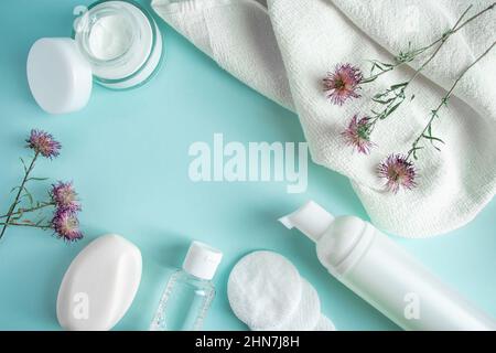 Produits cosmétiques et fleurs sèches sur fond bleu.Crème, lotion, savon et tampons de coton.Cosmétiques naturels à base de plantes.Soins de la peau, concept de bien-être.COP Banque D'Images